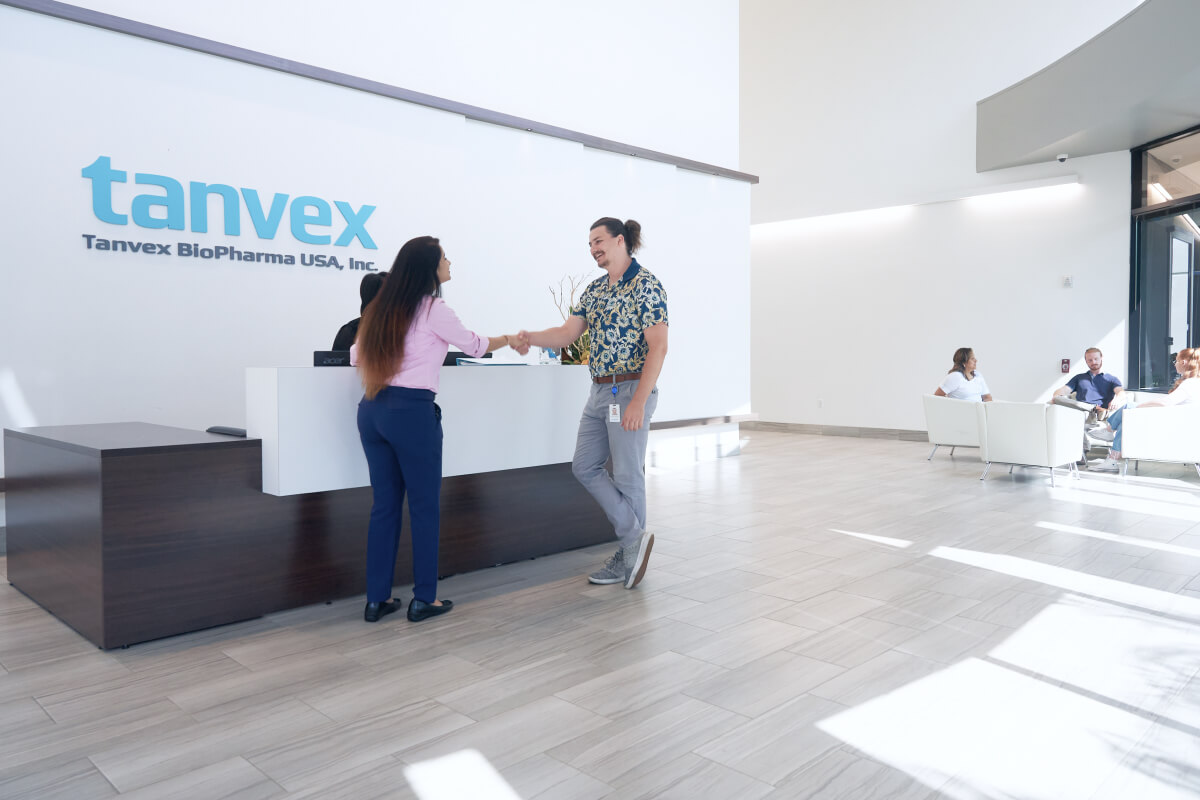 People shaking hands at Tanvex Biopharma USA headquarters